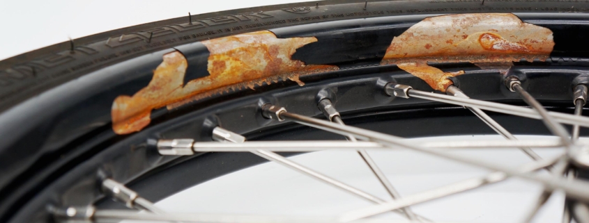Lackabplatzer an einer pulverbeschichteten Motorrad Speichenfelge.